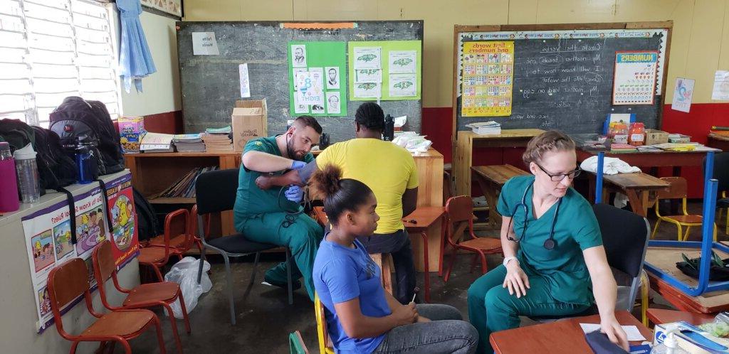 Photo of students in the accelerated second degree in nursing program, helping patients in Jamaica